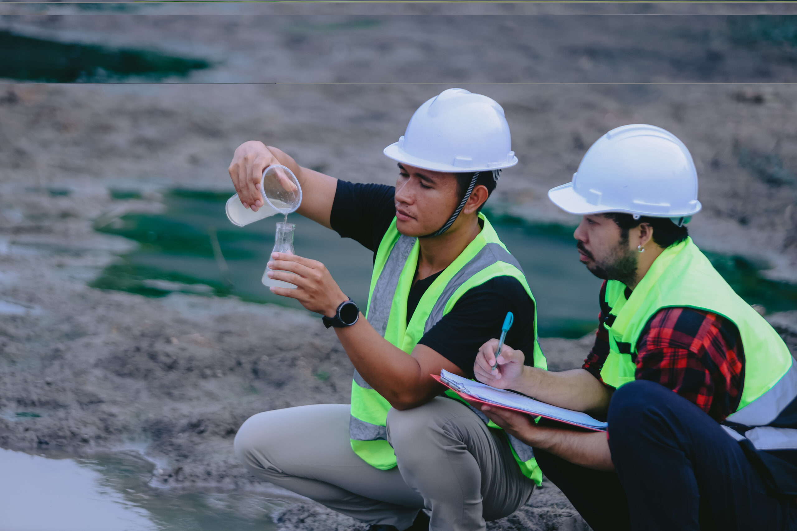 water-supply-engineering-working-water-recycling-plant-reuse Portrait of asian male scientist and asian male biologist comparing test tubes with samples of polluted water, taken from mountain river and discussing results of analysis during research